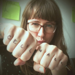 Image of Siobhan Braybrook (she/her) with "Cell Wall" written on her knuckles.