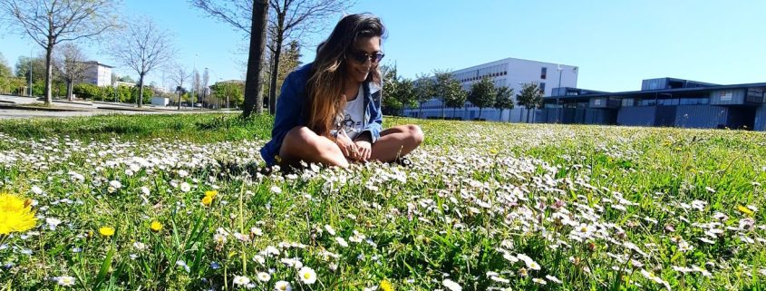 Photo of Jaishree sitting in a field of flowers in Aarhaus, Denmark